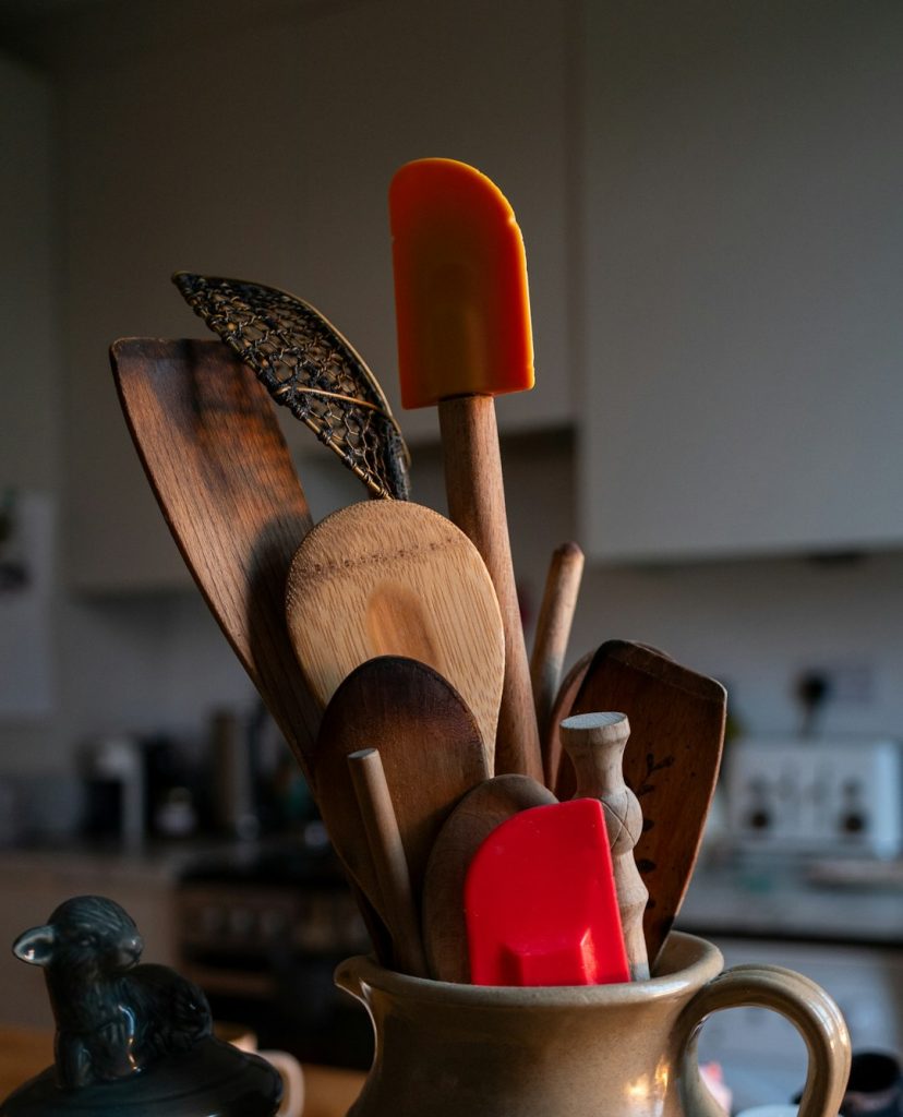 Jug of kitchen utensils in the early morning sunlight.